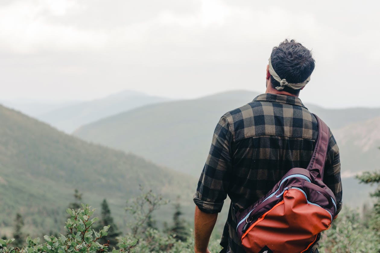 Hiker adjusting backpack fit on trail