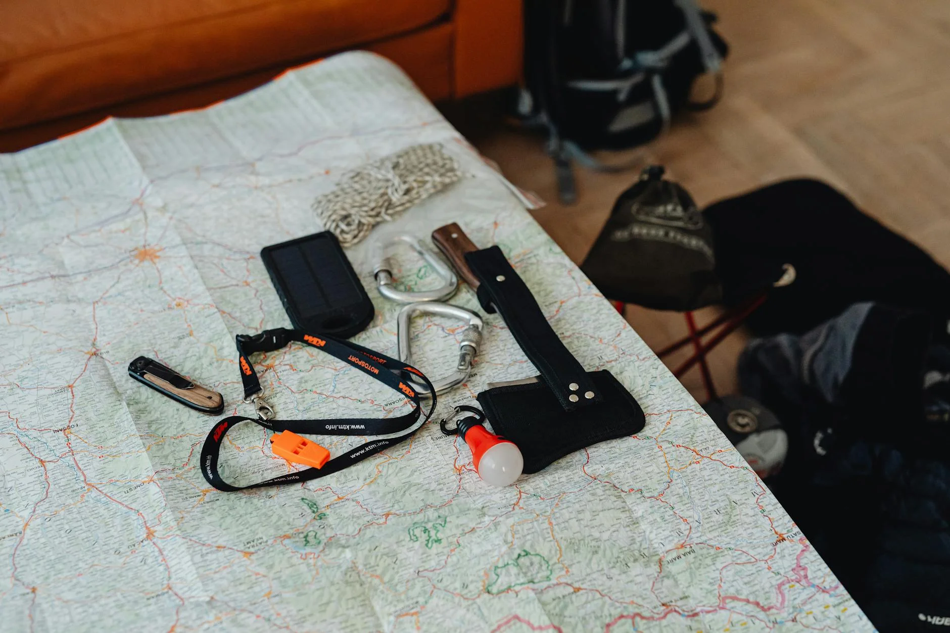 Hiking gear and tools laid out on a map