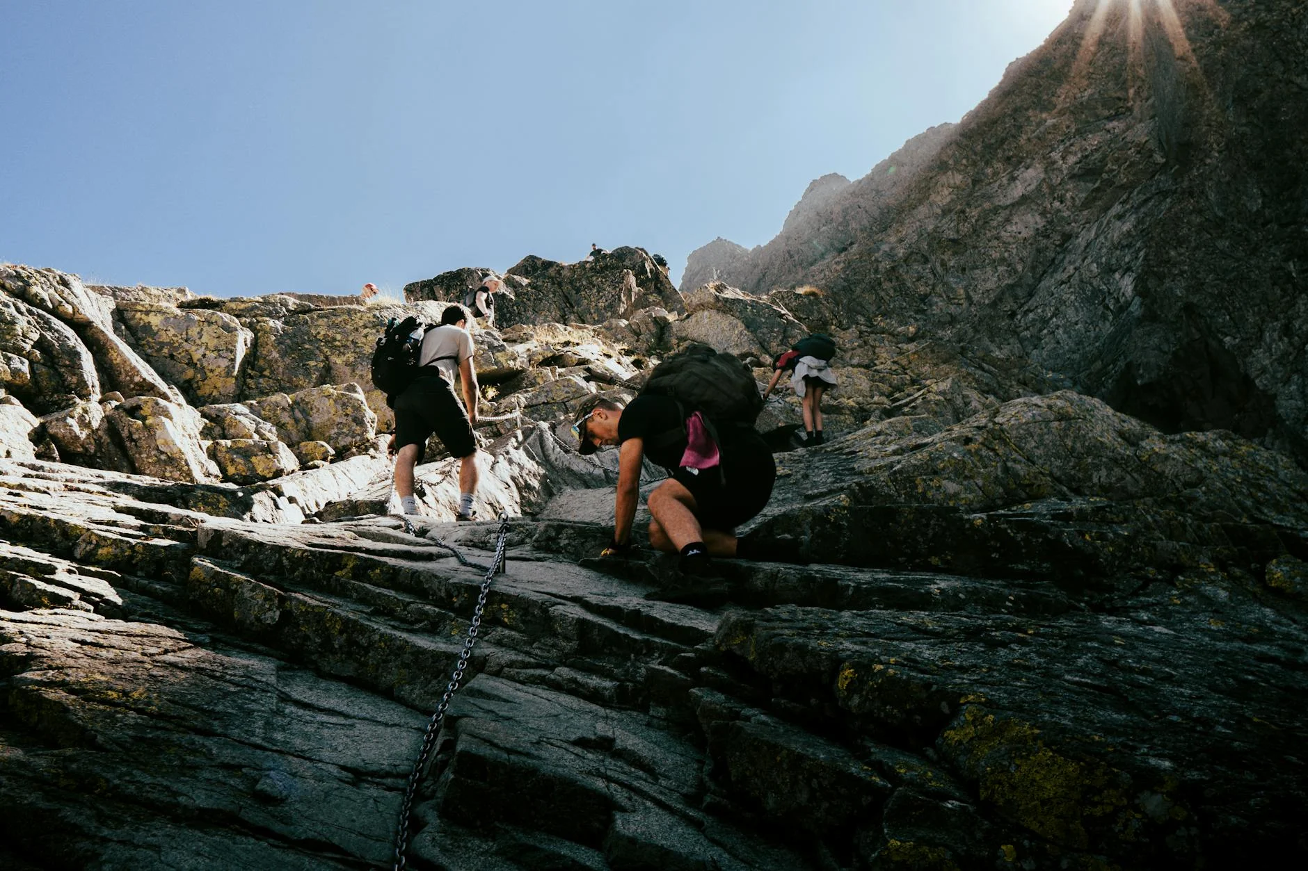 Hikers climbing a steep rocky mountain ridge