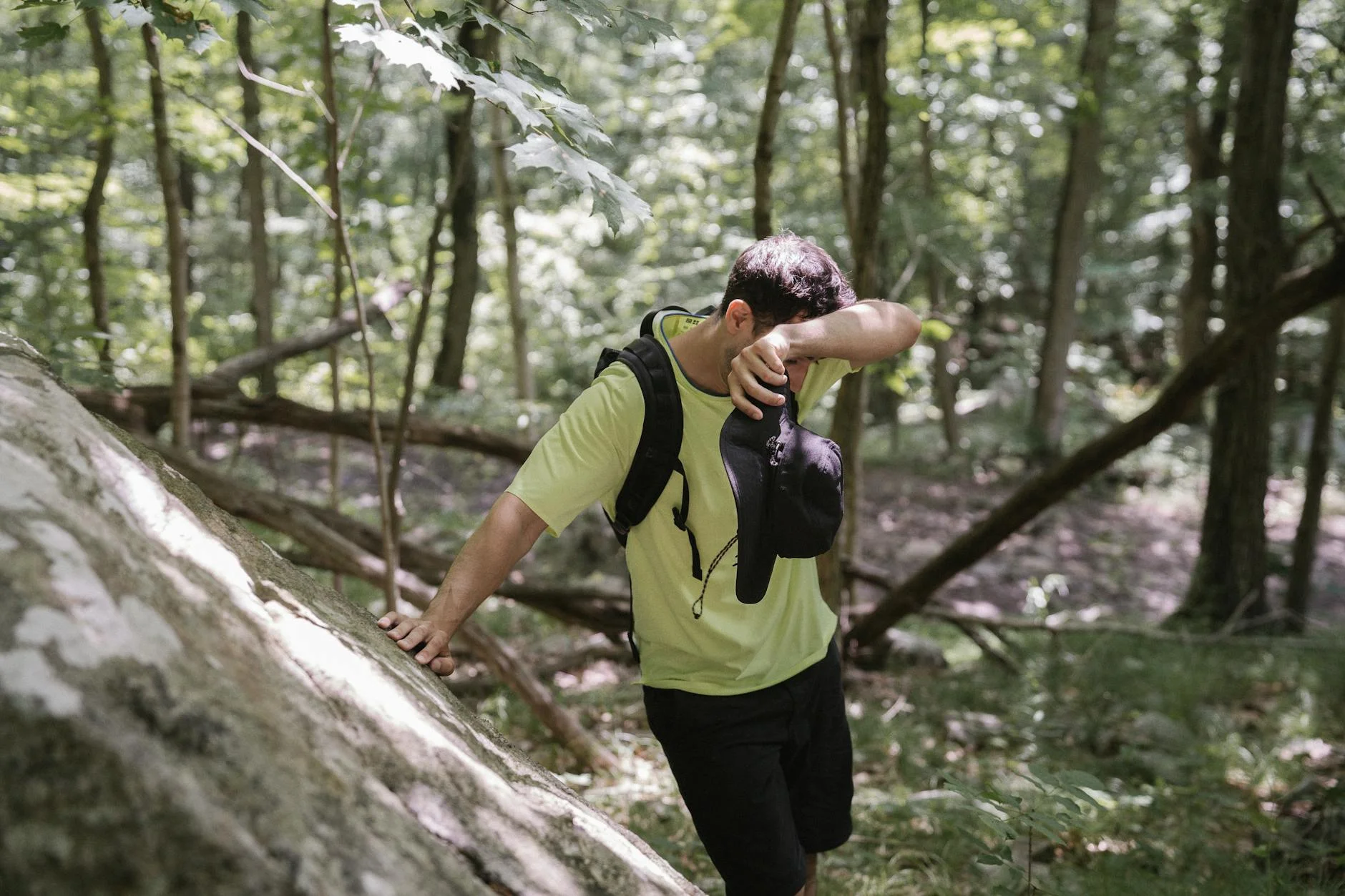Hiker in moisture-wicking shirt on a sunny forest trail