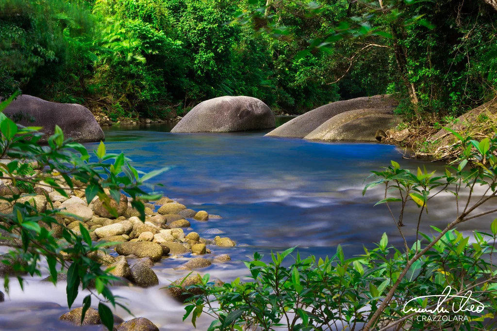 Hikers climbing near a waterfall pool