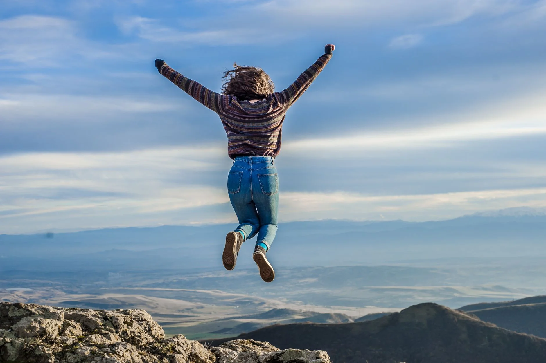Hiker celebrating at a rocky mountain summit