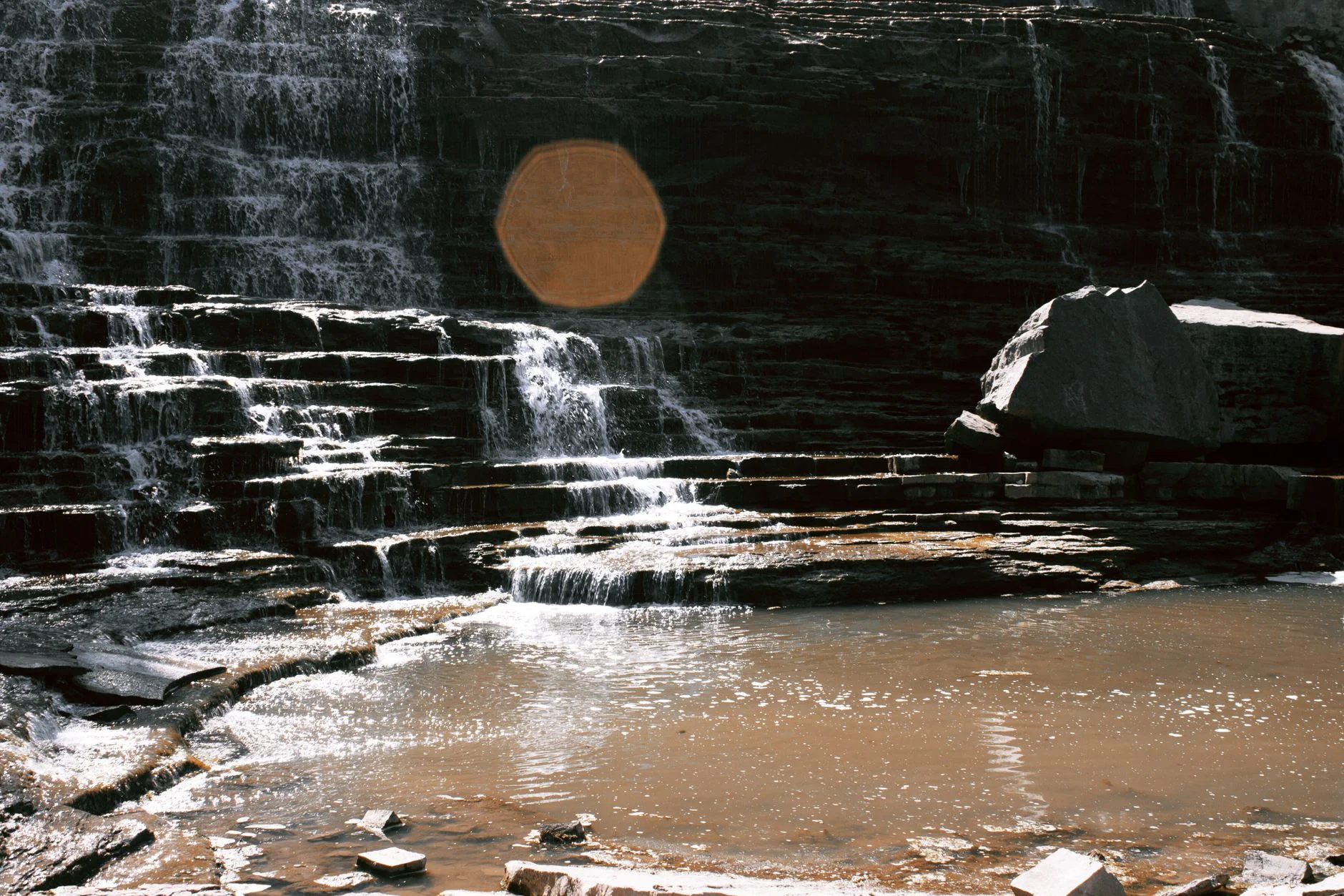 Waterfall cascading over rocky steps in a forest gorge